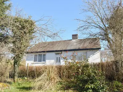 a white house in the middle of a field at Tynlon Villa in Bronant