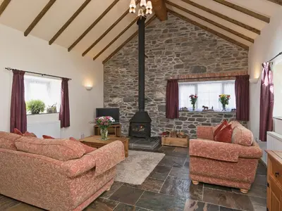 a living room with two couches and a fireplace at Yr Hen Stabl in Tregaron