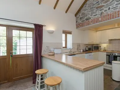 a kitchen with a counter and two stools at Yr Hen Stabl in Tregaron