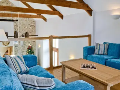 a living room with blue couches and a table at Felin Hedd Peaceful Mill in Tregaron