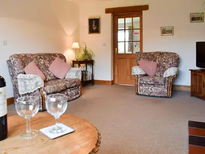 a living room with two chairs and wine glasses on a table at Marlais in Llangadog