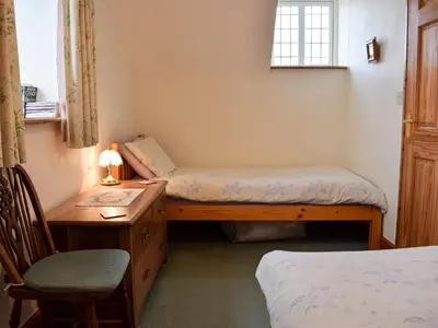 a bedroom with two beds and a desk and a chair at Marlais in Llangadog