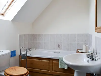 a bathroom with a tub and a sink and a toilet at Marlais in Llangadog