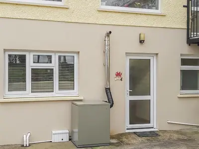 a white house with a refrigerator and windows at Penybryn in Llansadwrn