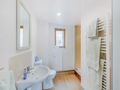 a white bathroom with a sink and a toilet at Field View in Cynghordy