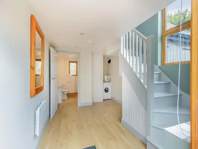 a hallway with a blue staircase and a bathroom at Field View in Cynghordy