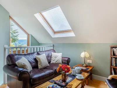 a living room with a leather couch and a table at Field View in Cynghordy