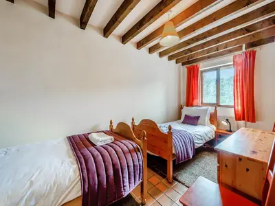 a bedroom with two beds and a desk and a window at Rhyblid Fach in Myddfai