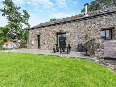 a stone house with a picnic table in front of it at Rhyblid Fach in Myddfai