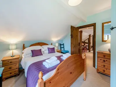 a bedroom with a large bed with purple pillows at Rhyblid Fach in Myddfai
