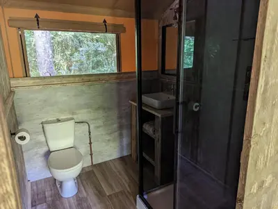 a small bathroom with a toilet and a sink at Luxury Safari Tent with Hot Tub in Ancient Woodland in Acton Scott