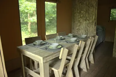 a dining room table with chairs and a table and a table and chairsuggest at Luxury Safari Tent with Hot Tub in Ancient Woodland in Acton Scott