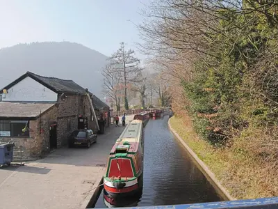 a group of boats in a canal next to a building at Crogen Coach House - Oqr in Llandrillo