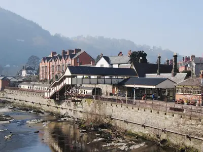 a town with a river and buildings and a bridge at Maesmor in Bala