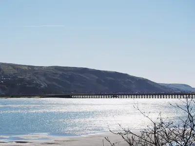a large body of water with a pier in the background at Barreg in Barmouth