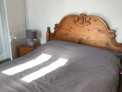 a bed with a wooden headboard in a bedroom at Barreg in Barmouth