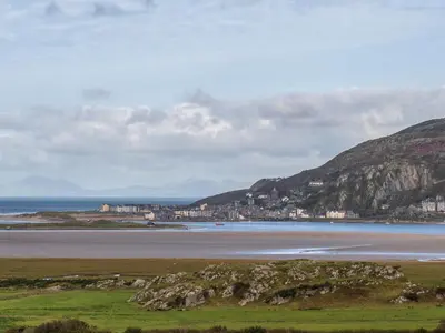 a view of a beach with a city and the ocean at Treetops in Fairbourne