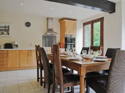 a kitchen with a wooden table with chairs around it at Hendre Barn Mawr in Abergynolwyn