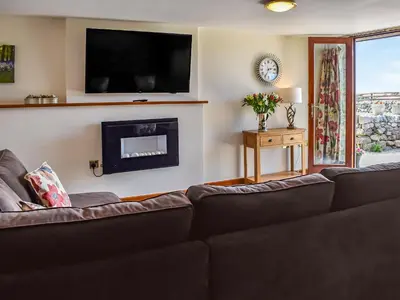 a living room with a couch and a fireplace at Beudy Hen in Harlech