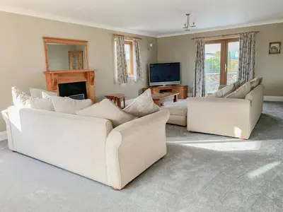 a living room with two white couches and a television at Bod Eithin in Harlech