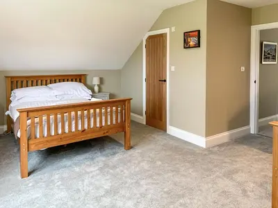 a bedroom with a wooden bed and a closet at Bod Eithin in Harlech