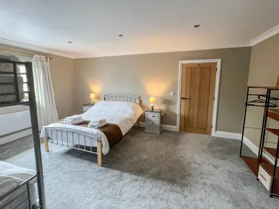 a bedroom with a bed and two lamps and a door at Bod Eithin in Harlech