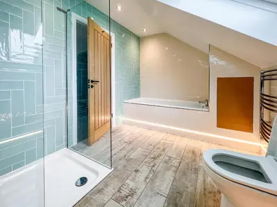 a bathroom with a toilet and a glass shower at Bod Eithin in Harlech