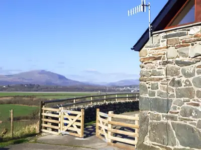 a church with a wooden gate and a fence at The Barn in Talsarnau