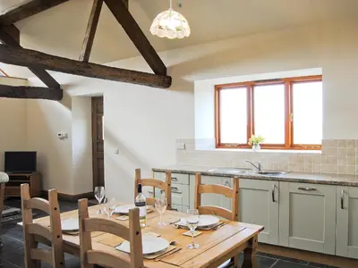 a dining room with a wooden table and chairs at The Barn in Talsarnau