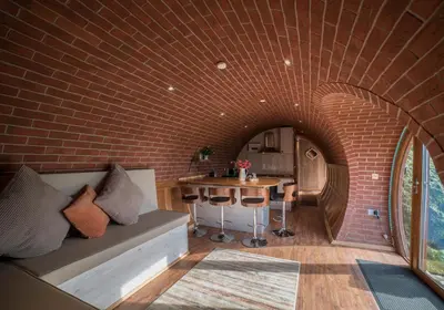 a room with a couch and a brick wall at Foxes View in Rhayader