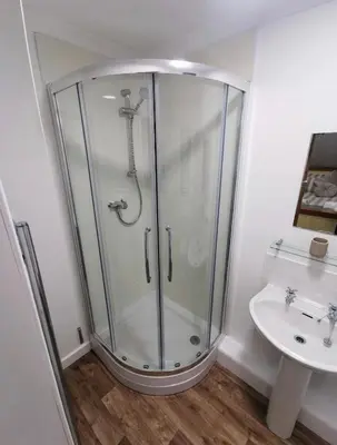 a bathroom with a shower and a sink at Bryn Mynach Guest House in Barmouth