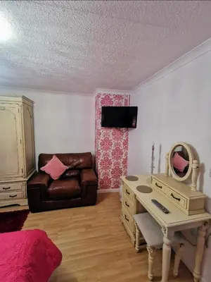 a bedroom with a desk and a couch and a table at Bryn Mynach Guest House in Barmouth