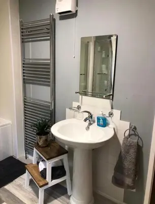 a bathroom with a sink and a mirror at Bryn Mynach Guest House in Barmouth