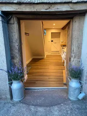 a hallway with two vases with purple flowers in them at The Cottage at Sychnant Farm in Talgarth