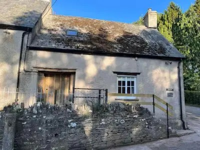 an old stone house with a gate in front of it at The Cottage at Sychnant Farm in Talgarth