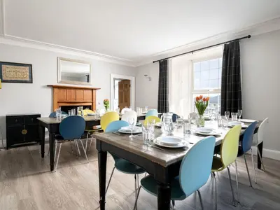 a dining room with a long table and chairs at Fron Dderw in Bala