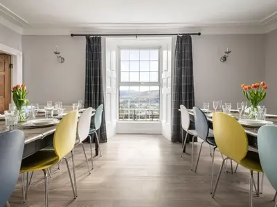 a dining room with tables and chairs and a window at Fron Dderw in Bala