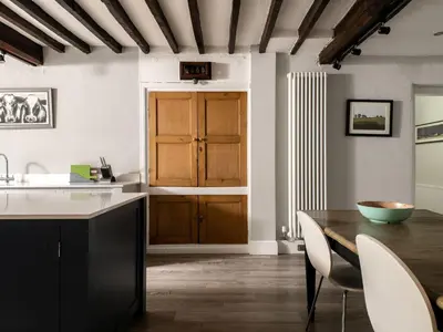 a kitchen with a wooden table and a wooden door at Fron Dderw in Bala