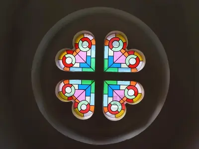 a cross on a plate with a stained glass window at Chapel House in Llangollen