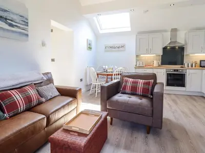 a living room with a couch and a chair at Tan Llech in Harlech