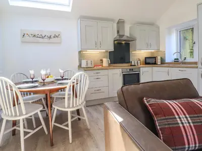 a kitchen and dining room with a table and a couch at Tan Llech in Harlech