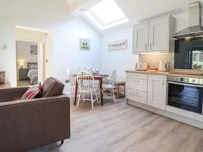 a kitchen and living room with a couch and a table at Tan Llech in Harlech