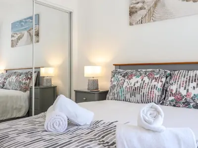 a bedroom with two towels on a bed with mirrors at Tan Llech in Harlech