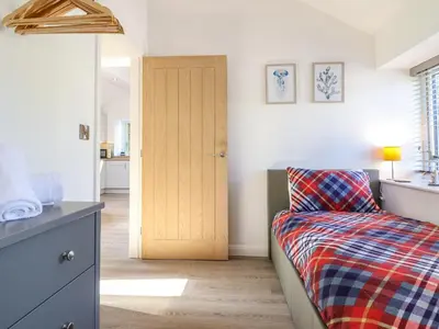 a bedroom with a bed and a wooden door at Tan Llech in Harlech