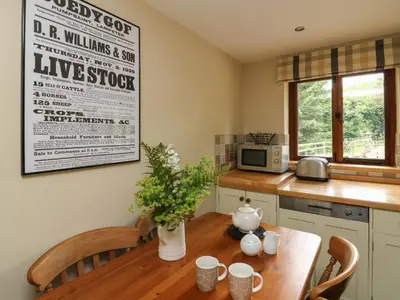 a kitchen with a wooden table with a vase on it at Nant Glas in Llanwrda