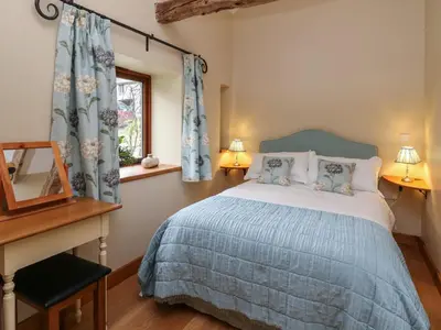 a bedroom with a bed and a desk and a window at Nant Glas in Llanwrda