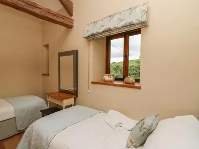 a bedroom with two beds and a window at Nant Glas in Llanwrda