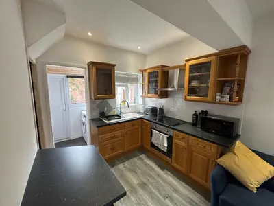 a kitchen with wooden cabinets and a black counter top at Newtown Townhouse in Newtown