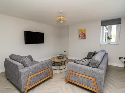 a living room with two couches and a tv at Rhiwmynach in Aberystwyth