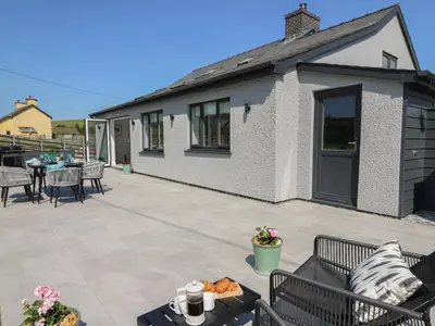 a patio with tables and chairs and a building at Rhiwmynach in Aberystwyth